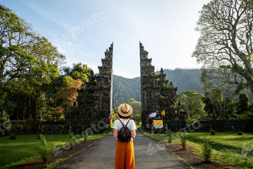 Preview: Woman traveler enjoying Balinese Hindu temple entrance. Female tourist during holidays. Copy space.