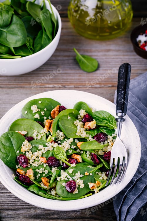 Preview: Green salad bowl with spinach, quinoa, walnuts and dried cranberries