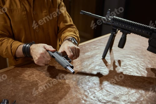 Preview: Male retailer or client reloading handgun portrait with selective focus