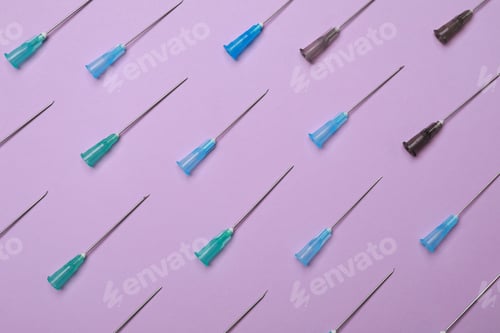 Preview: Disposable syringe needles on violet background, flat lay
