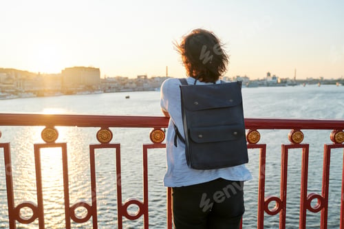 Preview: Woman with backpack standing with backpack on the bridge