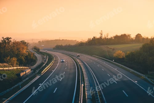 Preview: Aerial view of a truck on an empty highway with trees and hills in the background