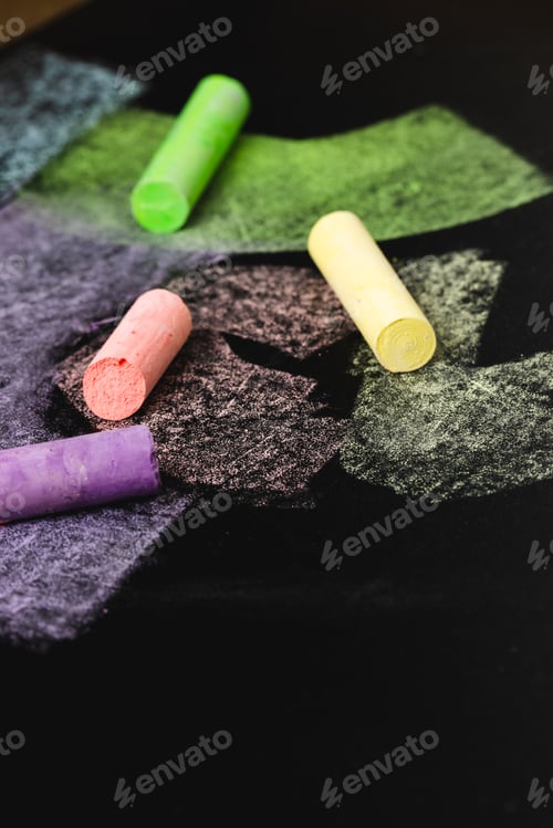 Preview: Vertical composition of colorful pastels on black surface with copy space