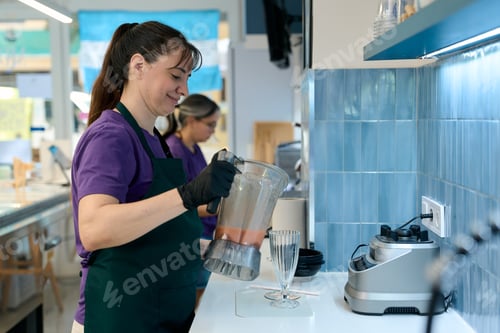 Preview: Ice cream shop employee pouring smoothie into glass