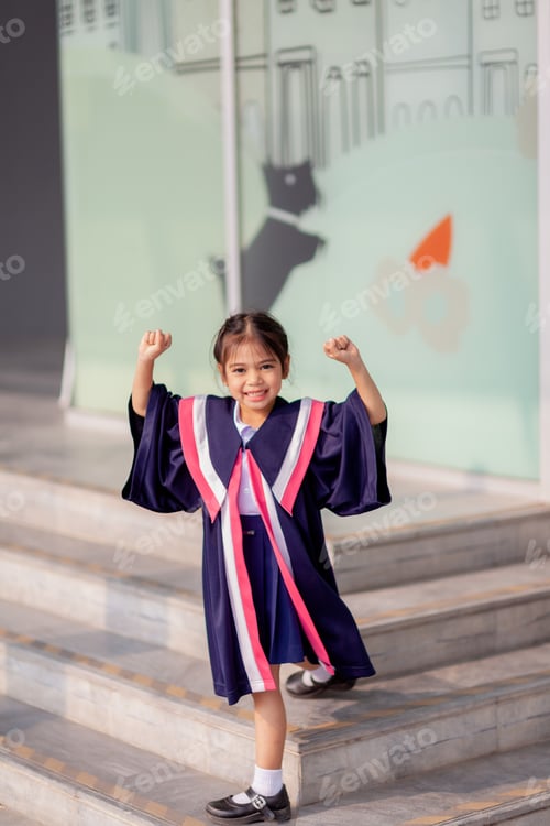 Preview: Happy Asian girls in graduation gowns on their graduation day at school.Graduation concept