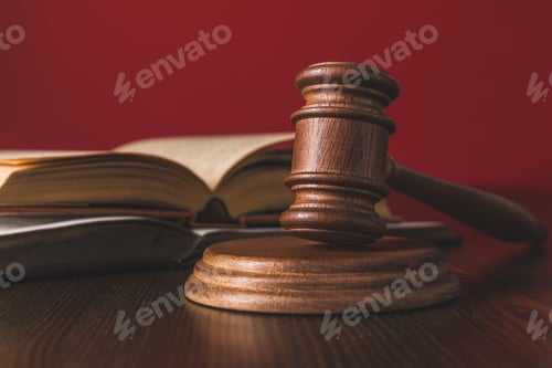 Preview: opened juridical books with hammer on wooden table, law concept