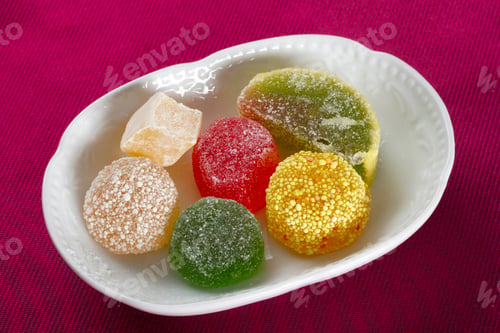 Preview: Close up view of multicolored sugary jelly candies on a bowl.