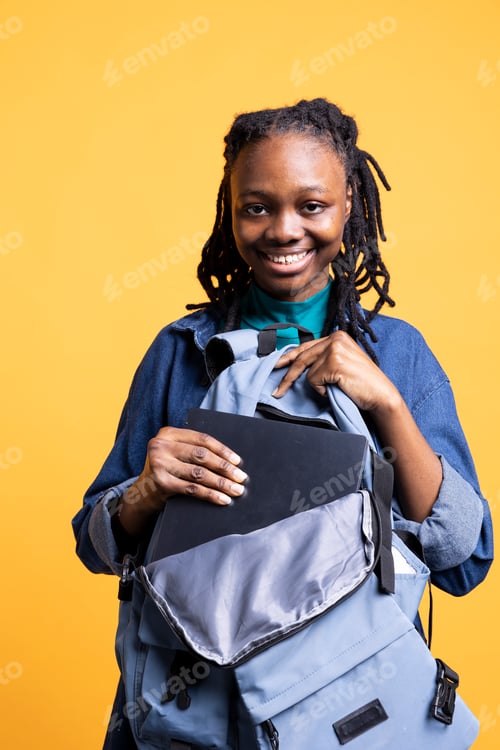 Preview: Joyful pupil packing notebook, preparing for university, studio background