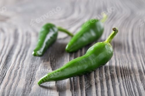 Preview: Green hot pepper on a wooden table