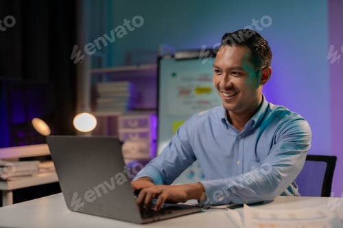 Preview: Commitment Asian businessman sitting at desk in office Working overtime late at night with document