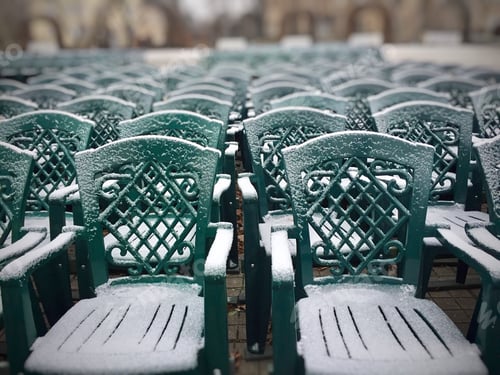 Preview: Bunch of green plastic chairs covered in snow