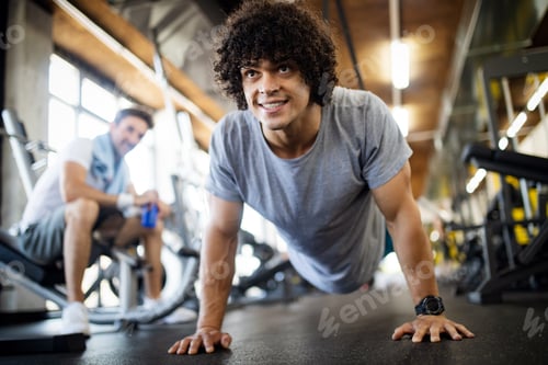 Preview: Fit healthy handsome man exercising in modern gym