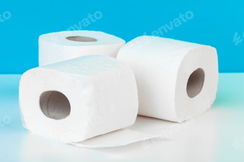 Preview: Three toilet paper rolls isolated on white table with blue background