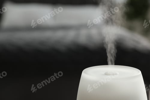 Preview: Modern aroma lamp against blurred background, closeup. Space for text