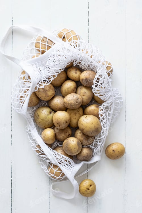 Preview: Fresh natural raw potatoes in white net bag