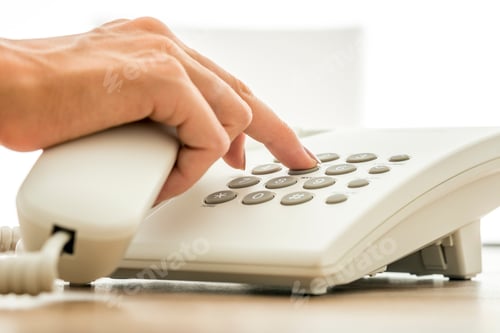 Vorschau: Nahaufnahme einer Sekretärin, die eine Telefonnummer auf einem weißen Festnetztelefon wählt