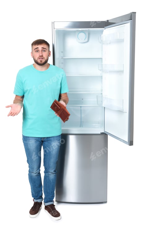 Preview: Young man with no money in wallet near empty refrigerator on white background