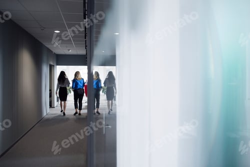 Preview: A group of people walking down an office corridor