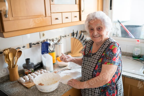 Preview: Portrait of smiling senior woman preparing meatballs in the kitchen