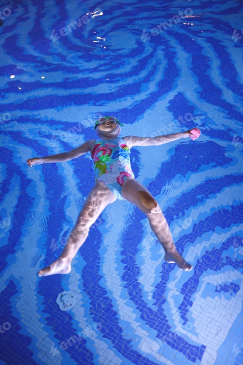 Preview: little girl doing exercises in the pool