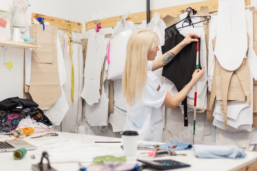 Preview: Fashion designer woman working on her designs in the studio. Creative workspace