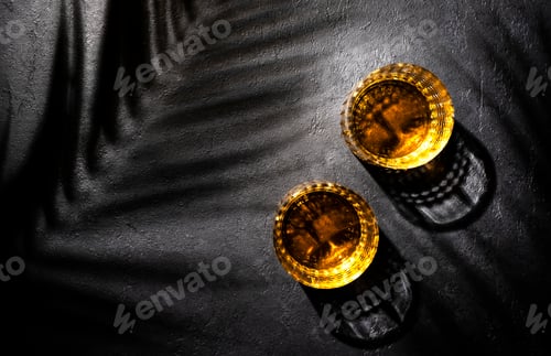 Preview: American bourbon whiskey in glasses and bottle, black background with shadow pattern