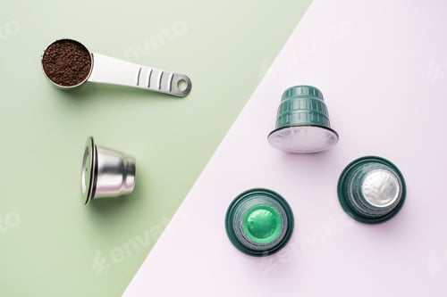 Preview: Metal reusable and plastic capsules for coffee machine on green and pink background, top view.