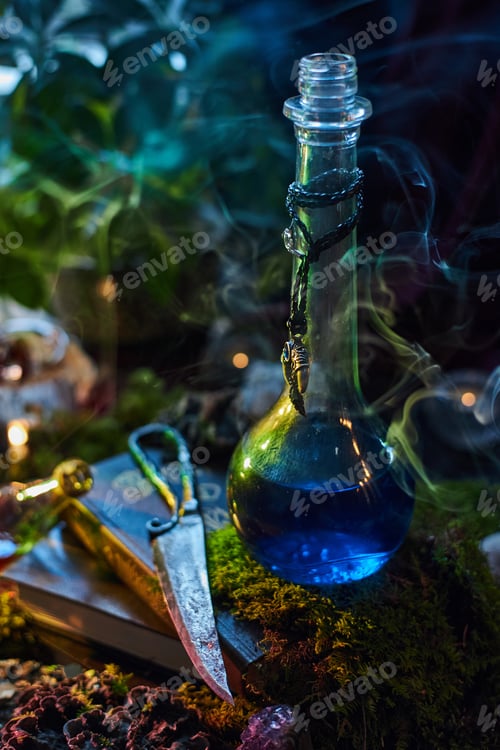 Preview: glass bottle filled with a glowing blue liquid stands among green plants and stones. Soft smoke