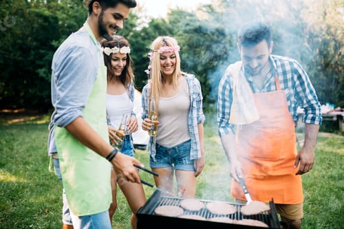 Preview: Group of friends making a barbecue together outdoors in the nature