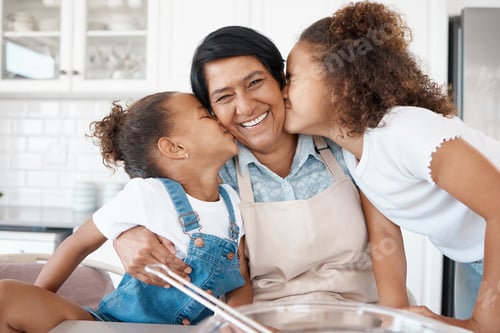 Preview: There are no sweeter smooches. Shot of two sisters kissing their grandmother while baking with her.