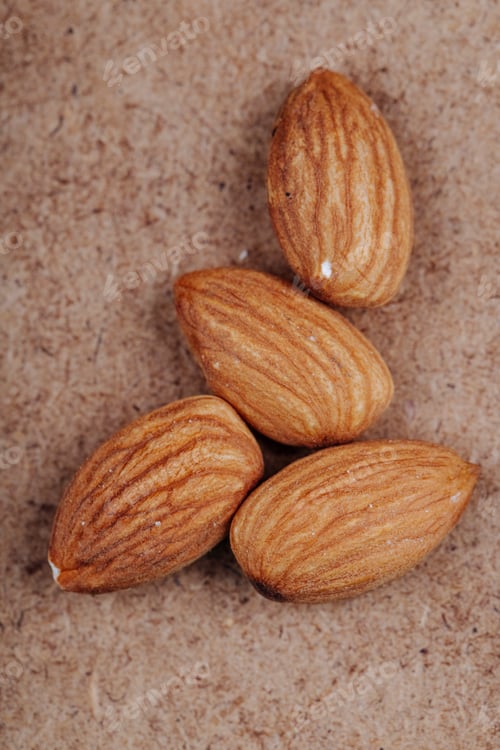 Preview: top view of almond nuts on old paper texture background