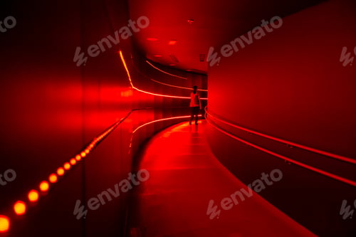 Preview: Man walking away via red neon lit corridor