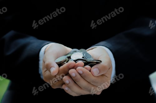 Preview: Businessman hand holding coins in financial concepts and financial investment business stock growth