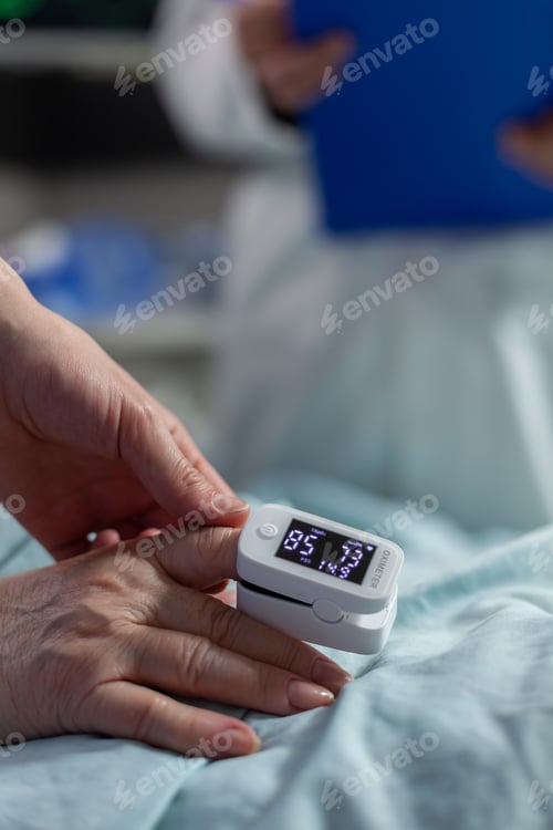 Preview: Close up of oxymeter attached on patient laying in hospital bed