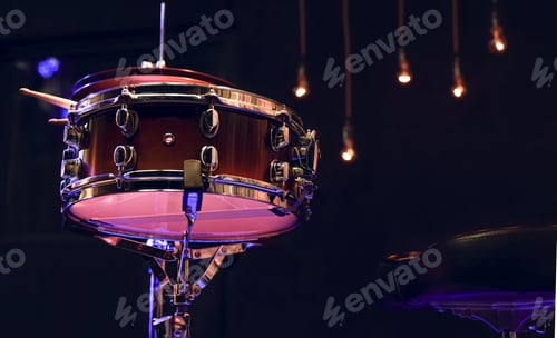 Preview: Snare drum and drumsticks close up in dark.