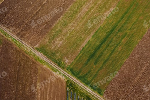 Preview: Aerial shot of highway road with green and brown farm fields in the countryside