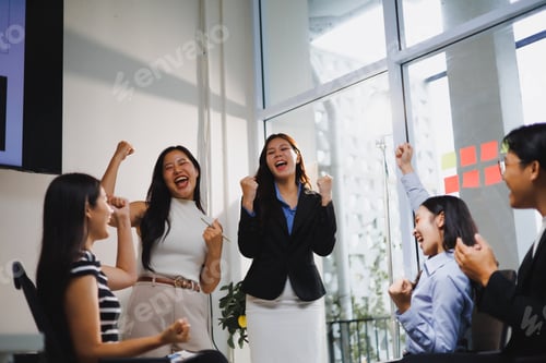 Preview: Excited business team celebrating success in the office