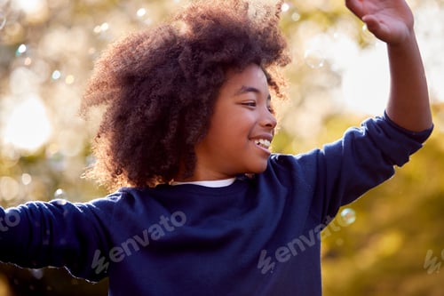 Preview: Smiling Boy Outdoors Having Fun Playing With Bubbles In Garden