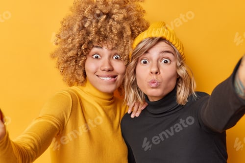 Preview: Positive surprised young women have fun and capture photo make selfie grimace at camera wear casual