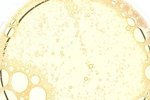 Preview: Abstract yellow oil bubbles background. Cosmetic liquid beauty product.