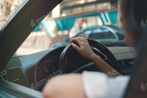 Preview: Close-up woman holding hand on steering wheel