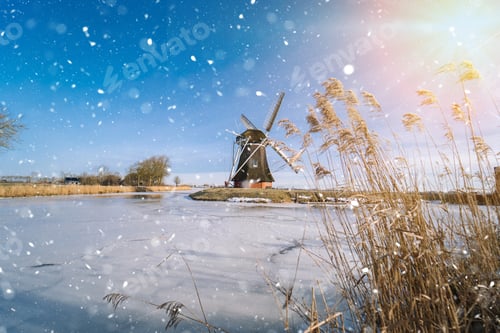 Preview: Typical winter dutch landscape with windmill. frozen canal in netherlands.