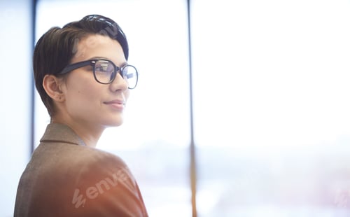 Preview: Smiling Young Businesswoman Standing by Window