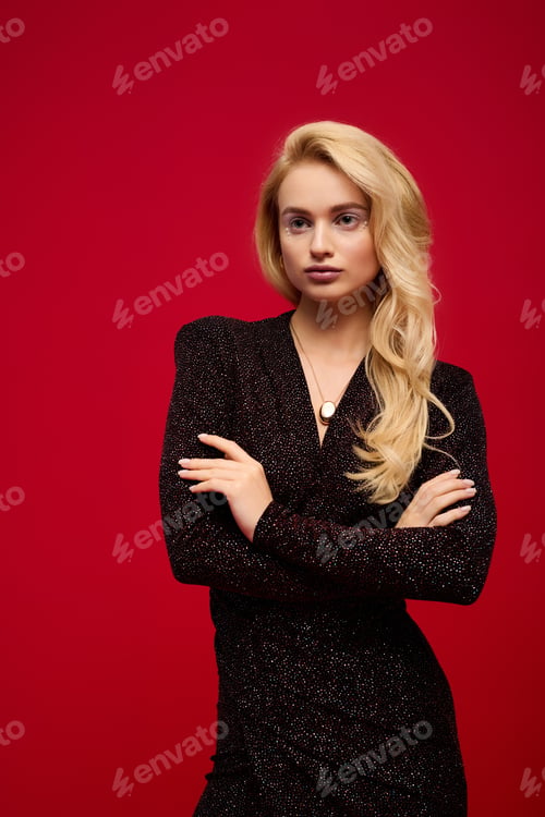 Preview: Blonde young woman in glamorous evening outfit enjoys festive winter vibes
