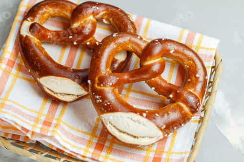 Preview: Two traditional soft Octoberfest pretzels in bread basket, close-up