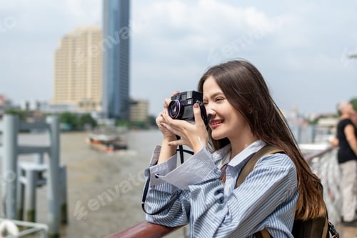 Preview: Asian woman traveler use camera taking a photo while traveling in city.