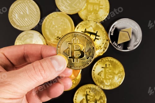 Preview: Hand of man choosing golden Bitcoin or BTC as preferred asset