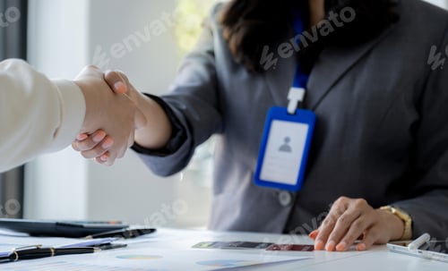 Preview: Hand shake after Employees present with mock up credit card payments to business customers.