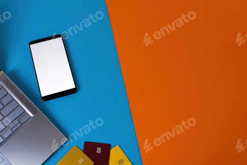 Preview: Laptop with a phone on a colorful surface with credit card holders on it - online shopping concept