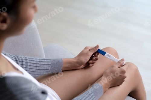 Preview: Woman holding pregnancy test